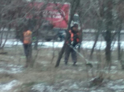 В снег и мороз рабочие косят траву на западе Волгограда