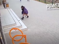 На видео попала девушка, средь бела дня бьющая стекла витрин в центре Волжского