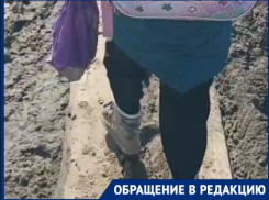 Волгоградка с дочкой по доске сквозь грязь пробираются до школы: видео