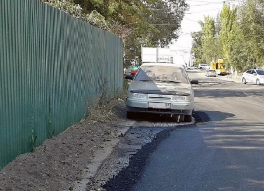 Дорожники не заморачивались и положили асфальт вокруг припаркованной легковушки в Волгограде