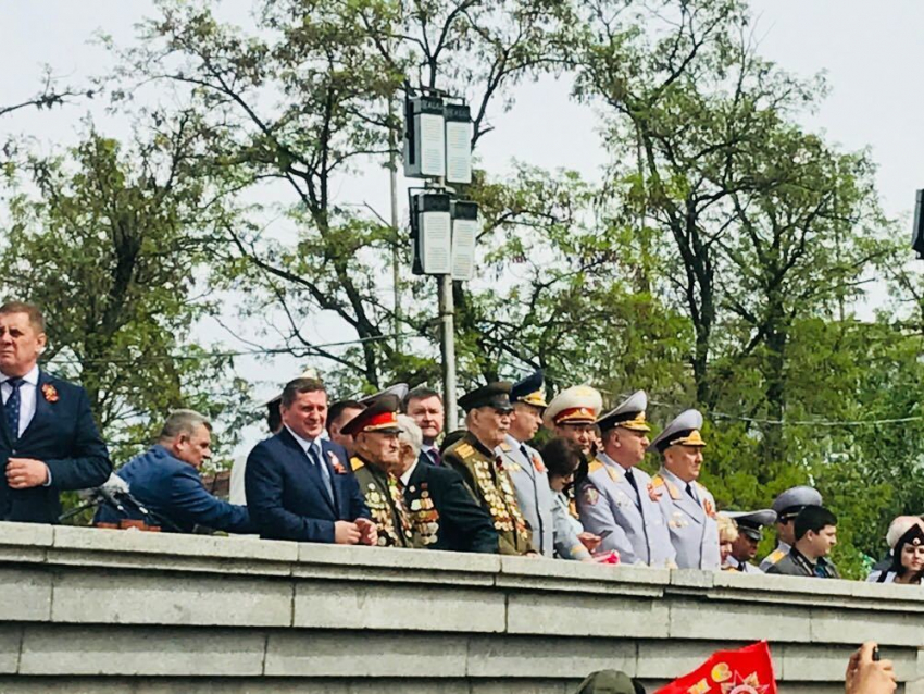 Губернатор Андрей Бочаров смотрит парад Победы в окружении ветеранов и силовиков