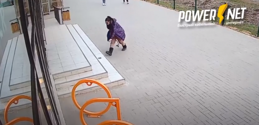 На видео попала девушка, средь бела дня бьющая стекла витрин в центре Волжского