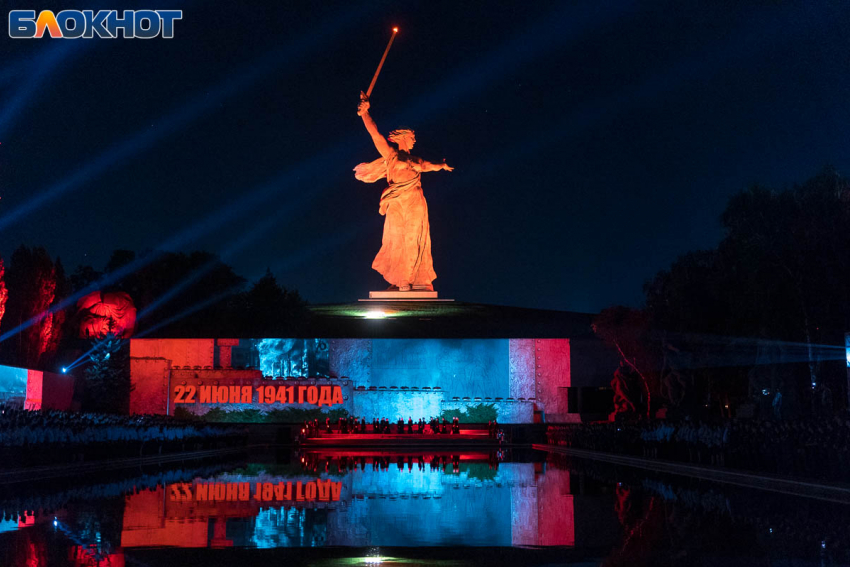 Мамаев Курган световое шоу. Световое шоу с изображение поющая девушке в красной косынке на улице.